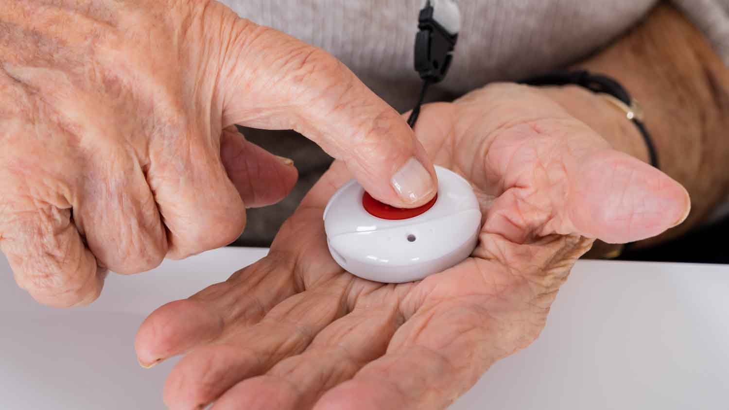 elderly person pushing a medical alert button